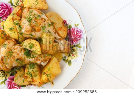 Roasted Chicken Leg And Potatoes On White Plate .