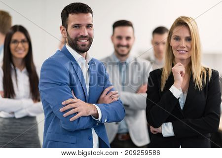 Successful team of young perspective businesspeople posing in office