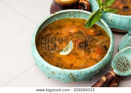 Solyanka Soup With Meat, Smoked Meat, Sausages, Pickled Cucumbers, Tomatoes, Olives, Herbs, Lemon In