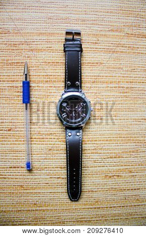 Wristwatch with writing pen for fulfilling the goals