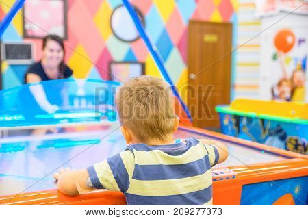 little kid plays in air hokey in Entertainment Center