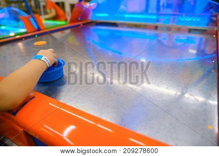little kid plays in air hokey in Entertainment Center