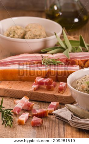 Canederli pasta with bacon on cutting board.