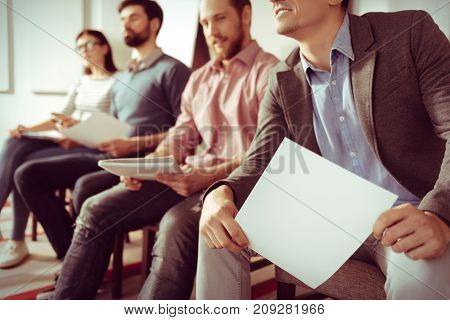 Teambuilding activity. Close up of a sheet of paper being in hands of a nice positive man while attending a teambuilding seminar