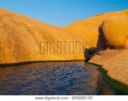Small water basin in Spitzkoppe rock formation, Namib Desert, Namibia, Africa.