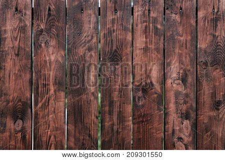 Brown, wooden board fence. Dark vintage wooden boards. burnt boards. Backgroundstextures fence painted. Front view. Attract beautiful vintage.