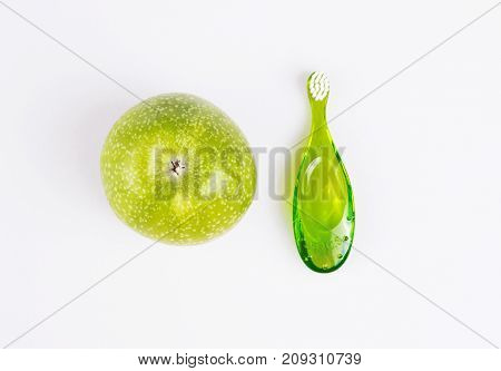 baby teeth care. green composition of toothbrush and teether on white background