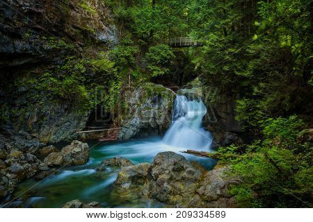 Twin Falls in Lynn Canyon Park with footbridge, North Vancouver, Canada. Long exposure.