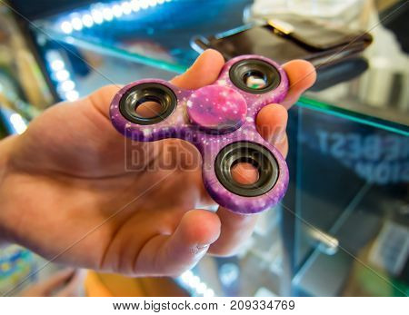 The hand holds the spinner before you buy it in the store