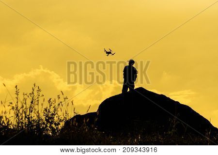 Silhouette of photographer with drone over the mountain tphotographer and ransportation concept
