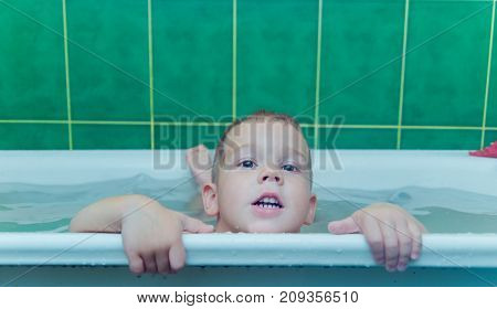 Boy in white bath tub on white background