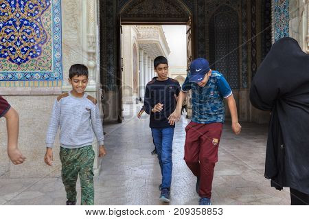 Fars Province Shiraz Iran - 19 april 2017: Shah Cheragh Shrine Iranian teenagers boys pass through the large gate of mosque Iran.
