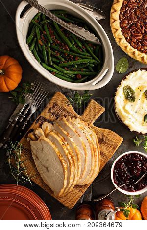 Sliced roasted tukey breast for Thanksgiving or Christmas dinner with side dishes overhead shot