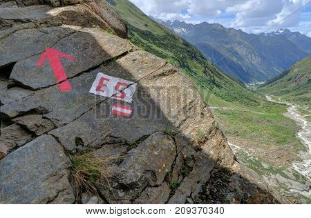 Red arrow indicator on a hike in southern side valley of the Upper Inntal which runs between the valleys 