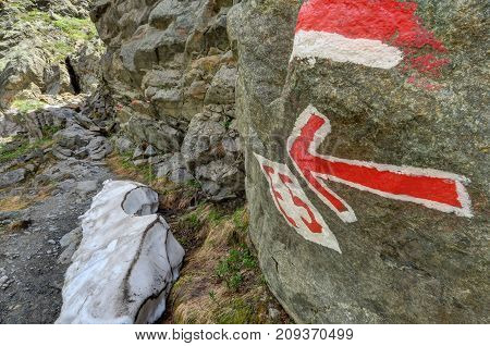 Red arrow indicator on a hike in southern side valley of the Upper Inntal which runs between the valleys 