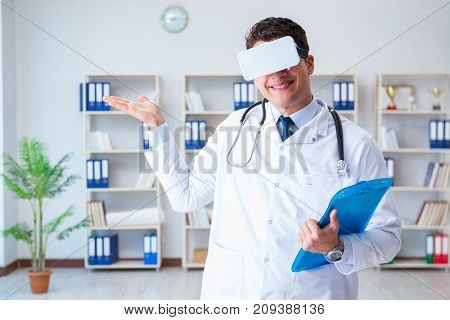 Young doctor with vr virtual reality headset working in the offi