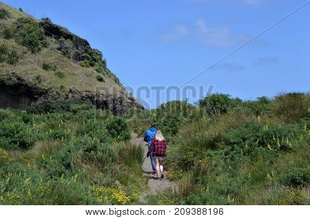 Couple Hiking In Karekare Beach New Zealand