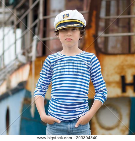 Portrait of a boy in a striped long sleeve T-Shirt (Telnyashka) and captain's cap.