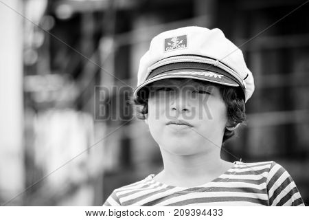 Portrait of a boy in a striped long sleeve T-Shirt (Telnyashka) and captain's cap. Black and white.