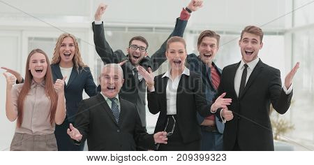 Victory in business. Happy businessman and  team on offi