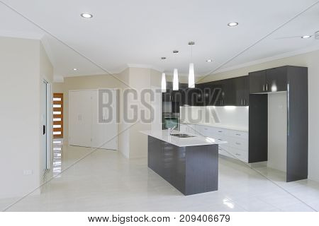 Modern kitchen with overhead lights and island work bench