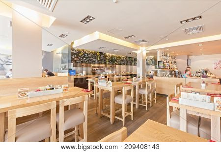 MOSCOW - AUGUST 2014: Interior of the international network of Italian home-cooked restaurants - "VAPIANO". Hall restaurant with an open kitchen and tables of oak