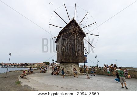 NESEBAR BULGARIA - AUGUST 21 2017: An old wooden windmill on the embankment in the old town. Nesebar is an ancient city and one of the major seaside resorts on the Bulgarian Black Sea Coast.