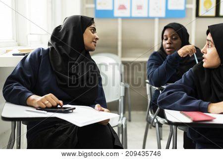 diverse muslim girls studying in classroom