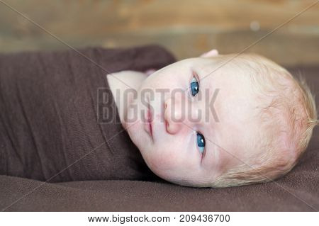 Temporary strabismus newborn baby with blue eyes