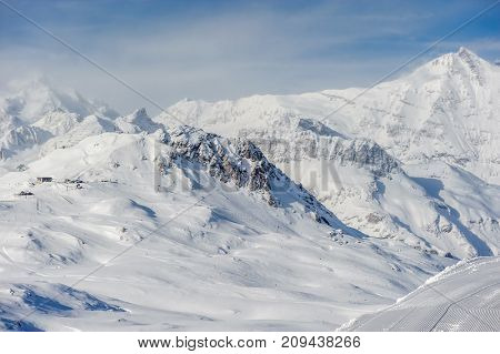 Alpine winter mountain landscape. French Alps covered with snow in sunny day. Val-d'Isere, France