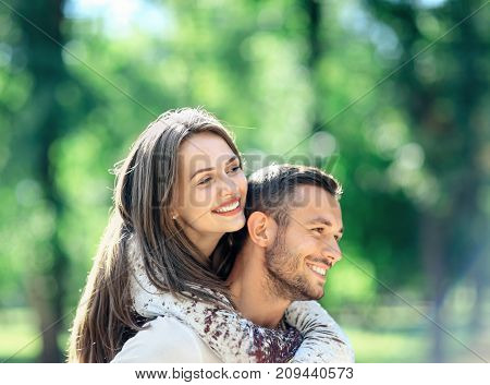 Loving Couple Man And Woman Having Fun Piggybacking In Park