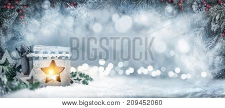 Christmas wide background in silver blue colors with a lantern fir branches ornaments and out of focus lights