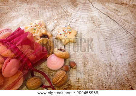 Various Christmas cookies in red sack isolated on wood background. Christmas decoration .