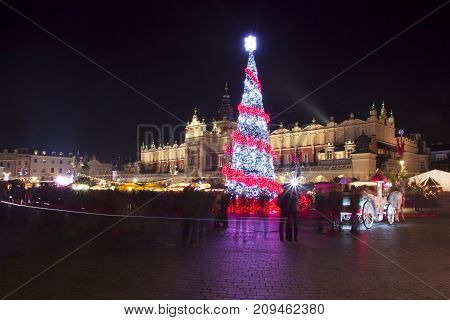 Poland Krakow Main Market square and Cloth Hall in winter during Christmas fairs decorated with Christmas tree.