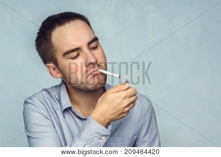 Young Man Lighting Cigarette
