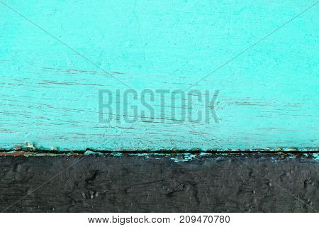Two-tone wooden background consisting of turquoise color with black.
