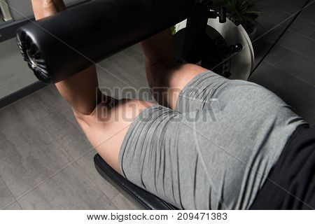 Muscular Man Exercising Quadriceps On Machine