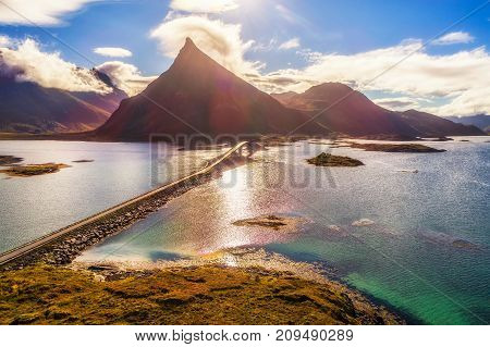 Aerial view of a scenic coastal road with a bridge on Lofoten islands in Norway on a sunny autumn day. HDR processed.