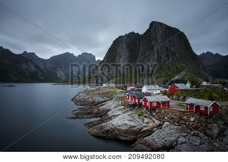 Traditional red rorbu cottages under the  Lilandstinden mountain peak in Hamnoy village, Lofoten islands, Norway. Long exposure.