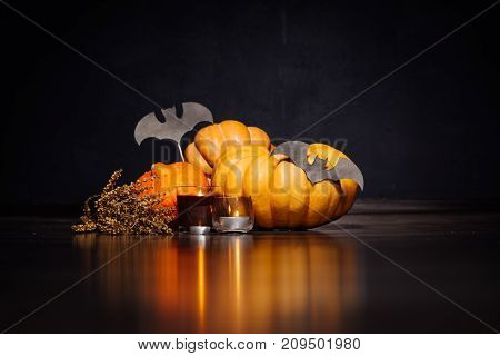 Halloween Carving Pumpkins and gloomy candles lie on a black surface