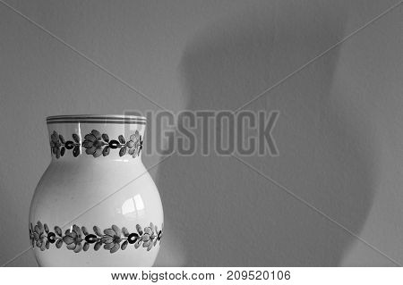 A jar with shadow on the wall.