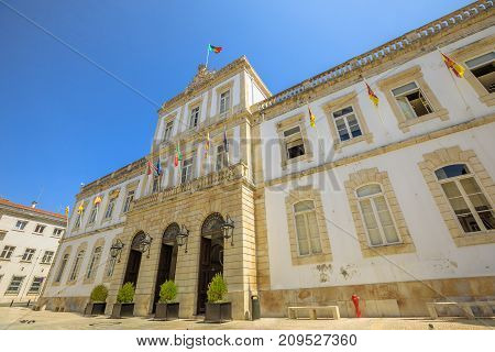 Facade of Town Hall of historic center of Coimbra in Praca 8 de Maio, sunny day with blue sky. Coimbra University Town in Central Portugal, Europe. Bottom view.