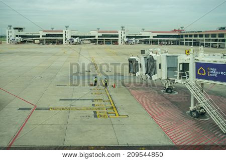 BANGKOK THAILAND  21 JULY 2017: Ground crew directing an incoming airplane into position to meet a jet-way bridge in Don Mueang international airport (DMK)