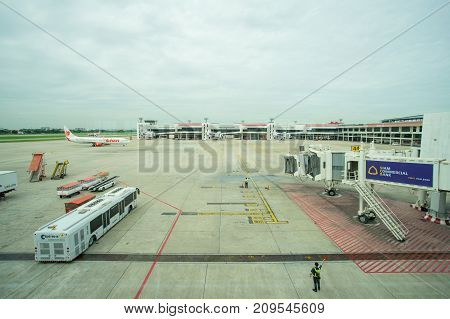 BANGKOK THAILAND  21 JULY 2017: Ground crew directing an incoming airplane into position to meet a jet-way bridge in Don Mueang international airport (DMK)