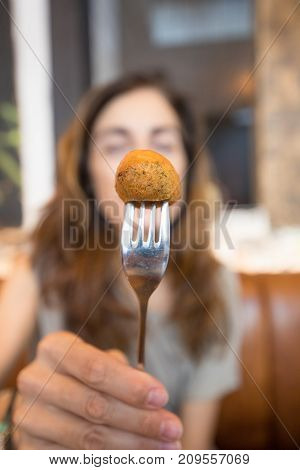 Close Up Codfish Fritter In Fork Woman Hand