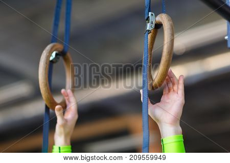 Young athlete with gymnastic rings in the gym. Close-up. The concept of sport.
