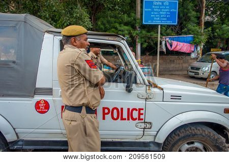 DELHI, INDIA - SEPTEMBER 25, 2017: A traffic policeman controling the traffic in Chandi Chowk area of the city. Traffic congestion is common in India's towns and cities.