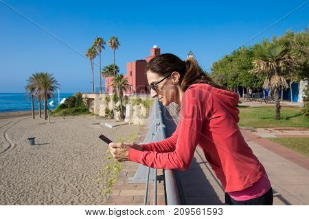 Woman Using Phone In Promenade Of Benalmadena