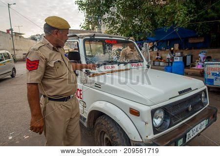 DELHI, INDIA - SEPTEMBER 25, 2017: A traffic policeman controling the traffic in Chandi Chowk area of the city. Traffic congestion is common in India's towns and cities.