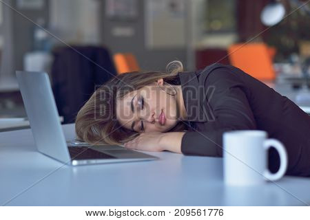 Young and beautiful businesswoman tired from work in the office.Woman holding her head